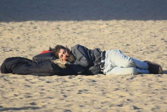 Bunul samaritean! Un român le pune perne sub cap beţivilor care dorm pe plajă în Vamă