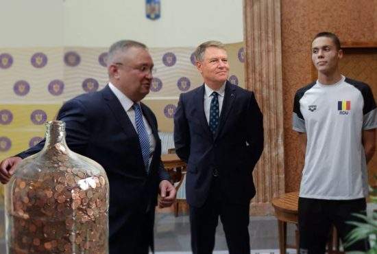 Premierul Ciucă i-a dat milionul de lei lui David Popovici în monede de 50 de bani